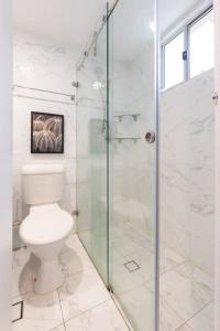 a bathroom with a toilet and a glass shower at Relaxed Private Double Room in Carramar - Close to Station - Shared Bathroom in Villawood