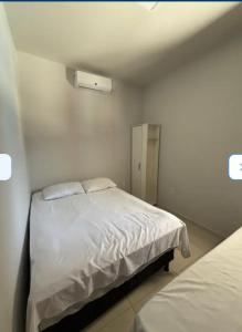 a small bedroom with two beds and a window at casa sol e mar 01 in Paripueira