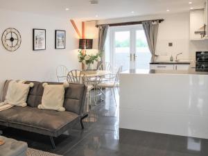 ein Wohnzimmer mit Couch und Küche in der Unterkunft Oak Cottage in Abergavenny
