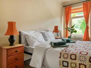 a bedroom with a bed with a dresser and a window at Mushroom Cottage in Ferndale