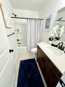 ein weißes Badezimmer mit Waschbecken und Toilette in der Unterkunft 4BR Townhome near Downtown-SLC Airport in Salt Lake City