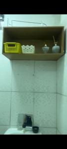 La salle de bains est pourvue d'un lavabo et d'une étagère avec de la vaisselle. dans l'établissement AP mobiliado, à Belém