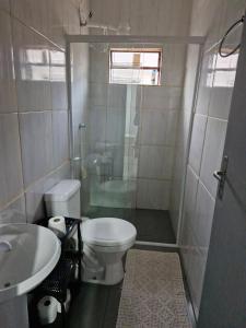 a bathroom with a toilet and a shower and a sink at House - Cantinho de Jacaré in Jacarèzinho +6 photos
