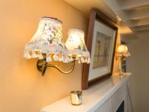 eine Lampe an einer Wand neben einem Spiegel in der Unterkunft Big Barns Cottage in Backies + 25 Fotos