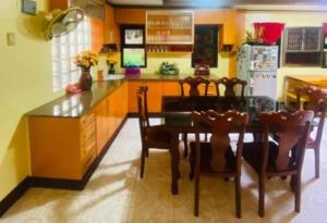 une cuisine avec une table, des chaises et un réfrigérateur dans l'établissement Namaste Olango Guesthouse by Hiverooms, à Sampong