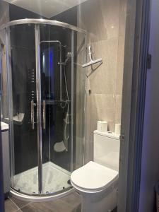 a bathroom with a toilet and a glass shower at KAYUMBA Properties LTD in Leeds