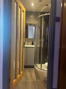 a bathroom with a shower and a sink and a toilet at KAYUMBA Properties LTD in Leeds