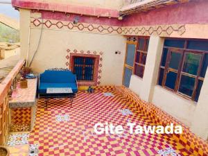 una casa con una cama azul sobre un suelo ajedrezado en Hôtel Tawada, en Azilal 2 fotos más