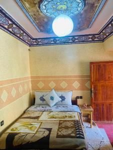 a bedroom with a bed with a painting on the ceiling at Hôtel Tawada in Azilal
