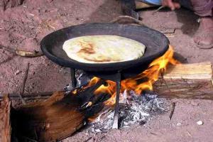 a pancake cooking in a pan over a fire at Hôtel Tawada in Azilal +2 photos