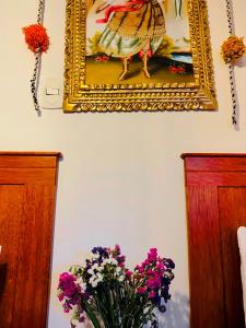 una pintura de una mujer en una pared con flores en ECOTERRA-SAN FRANCISCO Cusco, en Cusco