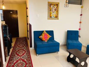a living room with two blue chairs and a pillow at ECOTERRA-SAN FRANCISCO Cusco in Cusco