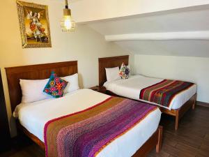 two beds in a small room with sidx sidx sidx sidx sidx at ECOTERRA-SAN FRANCISCO Cusco in Cusco