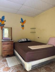 a bedroom with a bed with birds on the wall at Cute House in Sonsonate