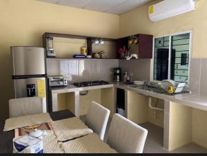a kitchen with a counter and a table with chairs at Cute House in Sonsonate