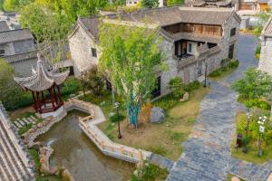 een bovenaanzicht van een gebouw met een vijver ervoor bij Floral Hotel Taipingli in Quanjiao