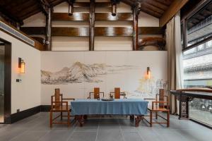 een eetkamer met een blauwe tafel en stoelen bij Floral Hotel Taipingli in Quanjiao