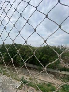 una valla de cadena con árboles en el fondo en Residencial Dalí, en Duque de Caxias