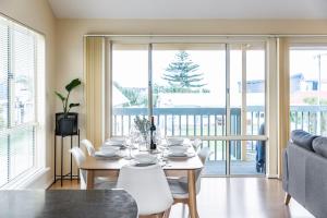 a dining room with a table and white chairs at Sunnys Beachhouse - 70 Hargreaves Rd, Middleton in Middleton