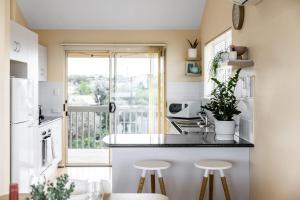 a kitchen with a counter and stools in front of a window at Sunnys Beachhouse - 70 Hargreaves Rd, Middleton in Middleton +15 photos