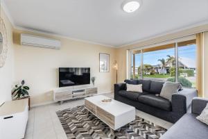 a living room with a couch and a tv at Sunnys Beachhouse - 70 Hargreaves Rd, Middleton in Middleton