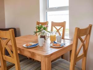 a wooden table with two plates of food on it at Gatekeepers Cottage Uk6728 in Lydstep