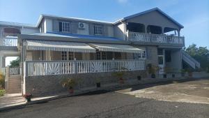 a house with a porch and a balcony at Maison d'hôte Trésor in Sainte-Anne