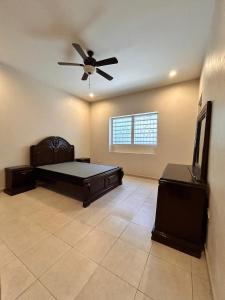 a large room with a bed and a ceiling fan at Auberge du Gouverneur, Rue 13-14J, Cap-Haitien, Haiti in Cap-Haïtien