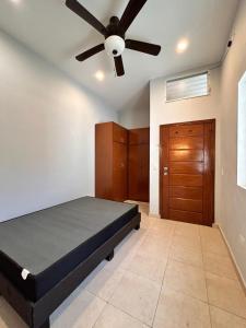 a bedroom with a bed and a ceiling fan at Auberge du Gouverneur, Rue 13-14J, Cap-Haitien, Haiti in Cap-Haïtien