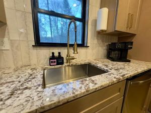 a kitchen counter with a sink and a window at Cozy Creekside cabin- 35m to Boone in Butler +27 photos
