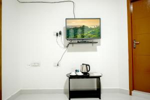 a television hanging on a wall with a table at Serenity heights cosy 2BHK in Jāmb