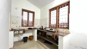 a kitchen with two sinks and two windows at Chillz Heaven Resorts - Ketti Palada in Coonoor