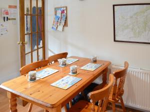 a wooden table with four chairs around it at Seashell Cottage in Nairn