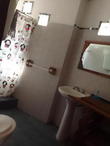 a bathroom with a sink and a toilet and a mirror at Espacio Kaskai in San Marcos Sierras