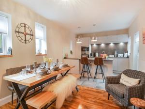 a living room with a table and a kitchen at Beaconsfield House in Mundesley