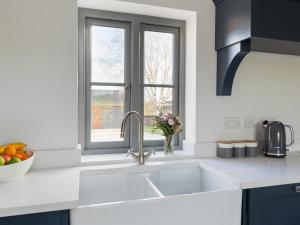 a white kitchen with a sink and a window at The Foundary - Uk36319 in Whitchurch +10 photos