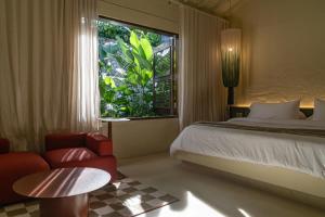 a bedroom with a bed and a window and a chair at Arde La Selva in Santa Fe de Antioquia +129 photos