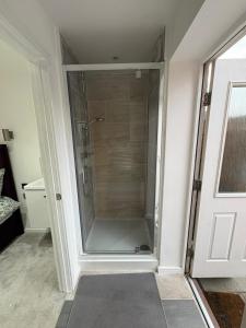 a shower in a bathroom with a glass door at WBC R4 - Private Studio Room in Bilston