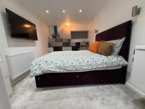 a bedroom with a large bed and a kitchen at WBC R4 - Private Studio Room in Bilston