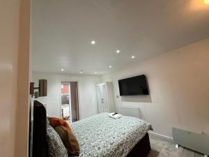 a bedroom with a bed and a flat screen tv at WBC R4 - Private Studio Room in Bilston