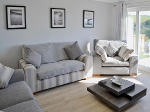 a living room with two couches and a coffee table at Sand Dunes in Tywardreath