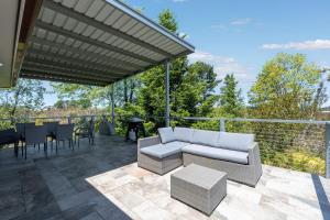 a patio with a couch and a table and chairs at Misty Haven at Wentworth Falls in Wentworth Falls