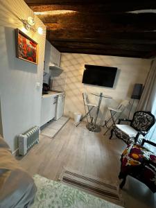 a living room with a flat screen tv and chairs at Cosy studio Montorgueil paris centre in Paris +1 photo