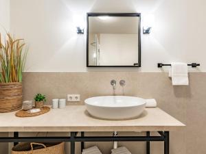 ein Badezimmer mit einem weißen Waschbecken und einem Spiegel in der Unterkunft Wening-Hüs in Boldixum + 6 Fotos