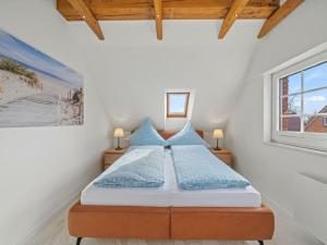 a bedroom with a bed with blue pillows and a window at Holiday apartment with 2 bedrooms in Timmel