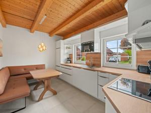 a kitchen with white cabinets and a wooden ceiling at Holiday apartment with 2 bedrooms in Timmel