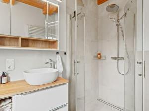 a white bathroom with a sink and a shower at Holiday apartment with 2 bedrooms in Timmel +22 photos