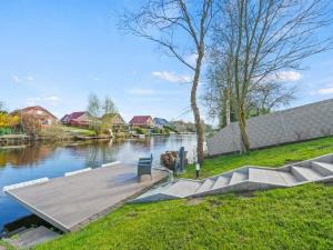 a wooden dock next to a river with houses at Holiday apartment with 2 bedrooms in Timmel