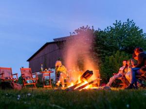 a group of people sitting around a fire at Steinbeck in the Thorstorf estate barn in Thorstorf