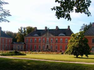 a large red brick building with a tree in the foreground at Steinbeck in the Thorstorf estate barn in Thorstorf